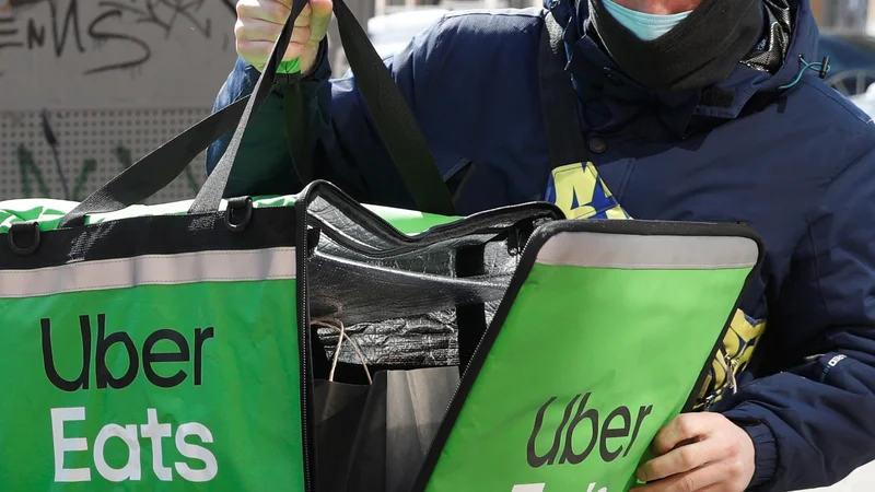 Fotografija: Uber Eats se sooča s kritikami na račun delovnih pogojev dostavljalcev. FOTO: Valentyn Ogirenko/Reuters