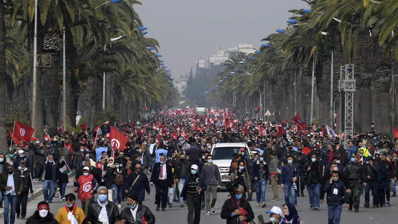 Fotografija: Podporniki zmerno islamistične stranke Ennahda mahajo z državnimi in strankinimi zastavicami med demonstracijami proti predsedniku Kaisu Saiedu in v podporo tunizijski vladi v prestolnici Tunis. FOTO: Fethi Belaid/Afp