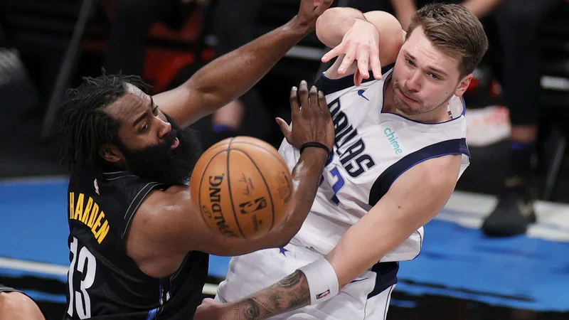 Fotografija: Luka Dončić se je takole boril za žogo z Jamesom Hardnom. FOTO: Sarah Stier/AFP