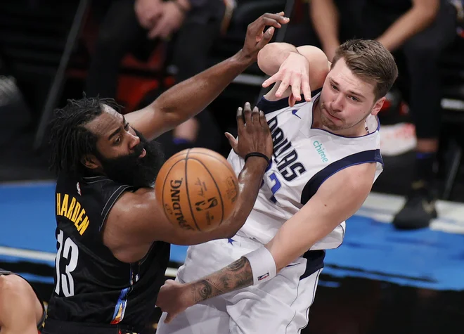 Luka Dončić se je takole boril za žogo z Jamesom Hardnom. FOTO: Sarah Stier/AFP