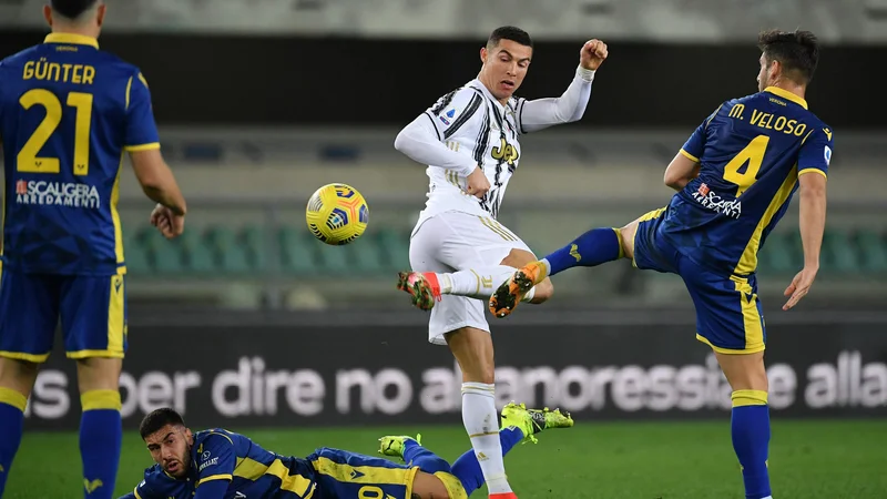 Fotografija: Konec tedna je poskušal onemogočiti Cristiana Ronalda prav njegov rojak v majici Verone Miguel Veloso. FOTO: Isabella Bonotto/AFP