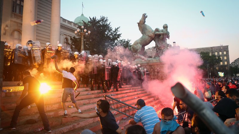 Fotografija: Ko je srbski predsednik Aleksandar Vučić julija lani napovedal policijsko uro za en konec tedna, je na tisoče ljudi napadlo parlament. Protestnike so zastrašili člani kriminalnih skupin, ki jih Vučić zdaj preganja. FOTO: Oliver Bunic/AFP