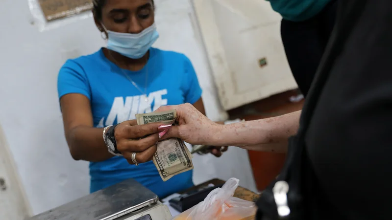 Fotografija: Dolar v vsakdanjem življenju vse bolj izpodriva bolivar. FOTO: Manaure Quintero/Reuters