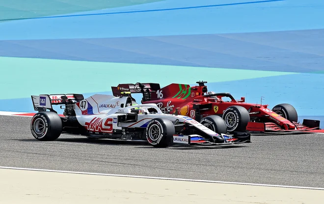 Mick Schumacher (levo) se je takole na proge znašel tik ob Ferrarijevem zvezdniku Charlesu Leclercu. FOTO: Mazen Mahdi/AFP