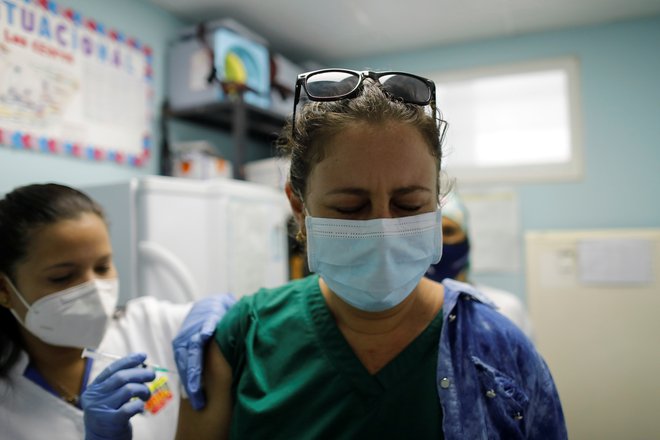 Kubanski zdravstveni delavci se cepijo s kitajskim cepivom, kmalu naj bi imeli na voljo tudi takšno domače izdelave. FOTO: Stringer/Reuters