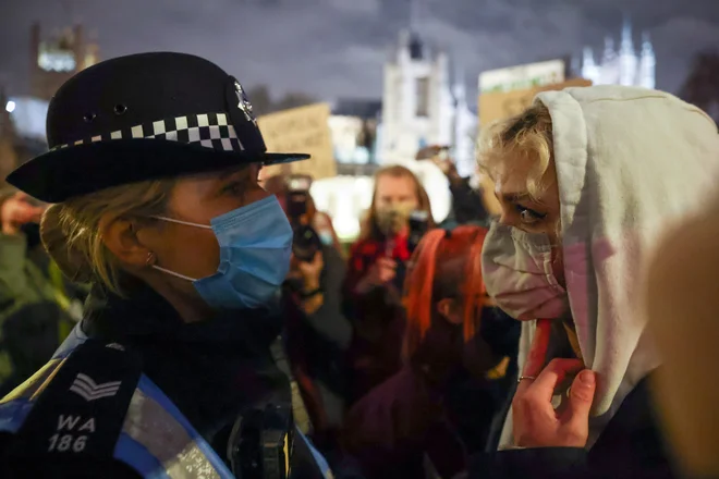 Nedeljski protest pred britanskim parlamentom, na katerem so udeleženci opozarjali tudi na nesorazmerno silo, ki jo je noč prej na Clapham Commonu uporabila policija. FOTO: Henry Nicholls/Reuters