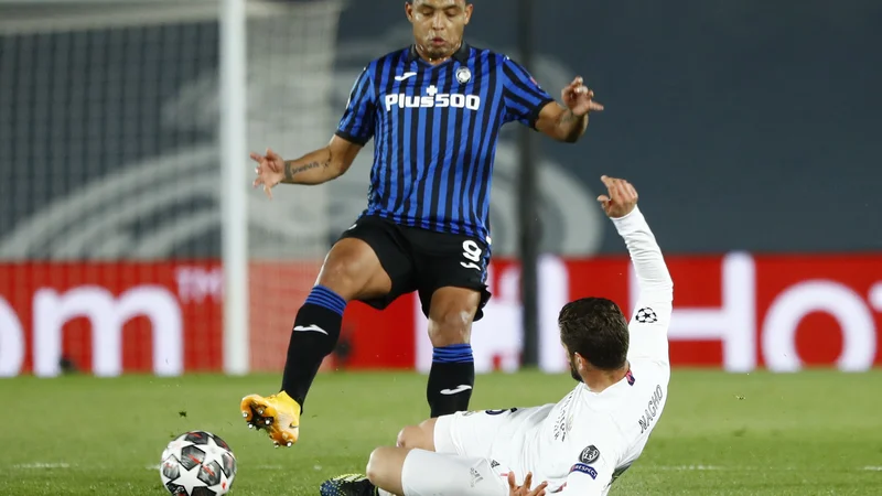 Fotografija: Atalantin strelec Luis Muriel je v napadu dobil prednost pred Duvanom Zapato. FOTO: Juan Medina/Reuters