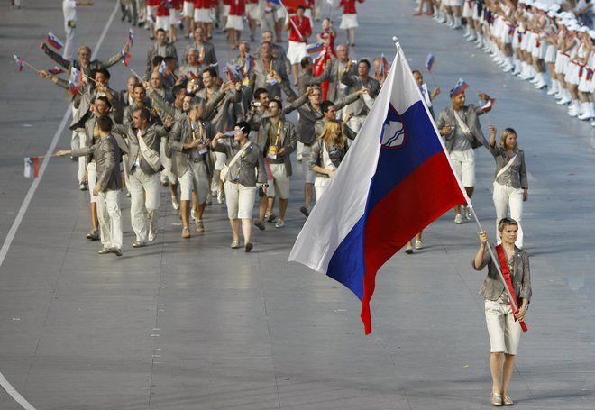 Ob desetih moških je Urška Žolnir ena od petih žensk, ki so na otvoritvenih slovesnostih olimpijskih iger nosile slovensko zastavo. To je bilo v Pekingu 2008. Foto Mike Blake/Reuters