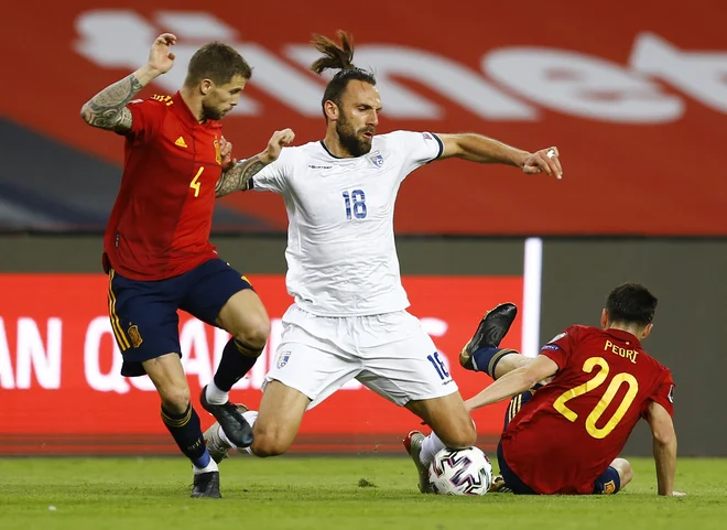 Kosovski reprezentant Vedat Muriqi (v beli majici) ni imel veliko možnosti proti španskima tekmecema Iñigom Martinezom in Pedrijem. FOTO: Marcelo Del Pozo/Reuters
