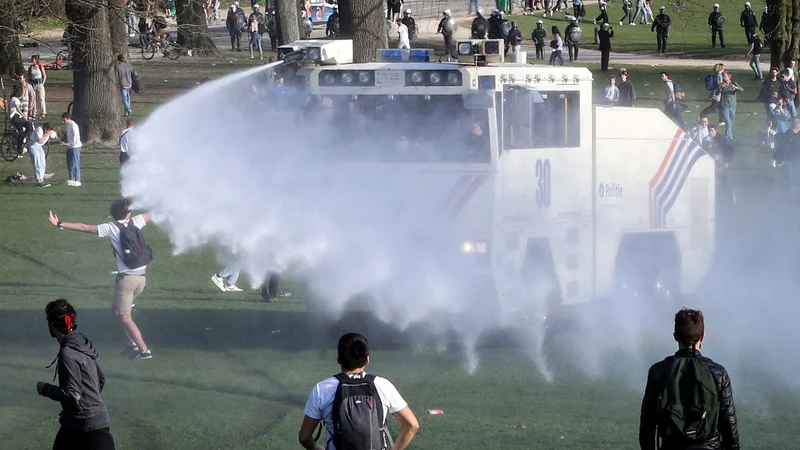 Fotografija: Mladi v Bruslju so se, siti omejevalnih ukrepov, množično zbrali v parku, posredovala je tudi policija z vodnim topom. Foto Francois Walschaerts/AFP