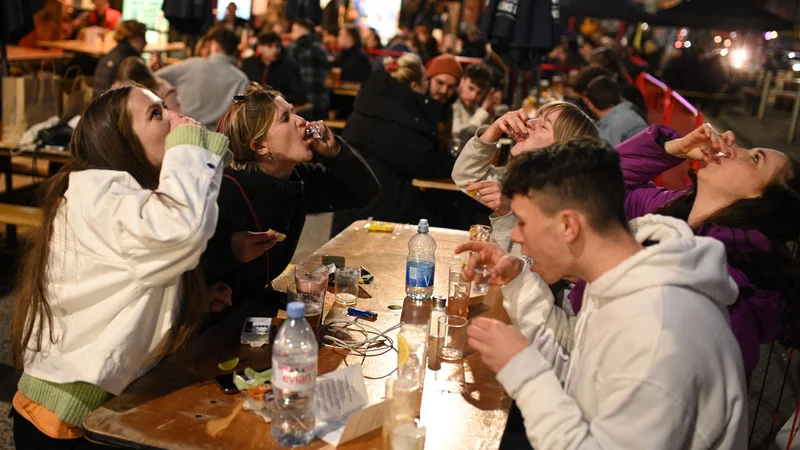 Fotografija: Po 97 dneh oziroma prvič po 5. januarju, ko so v Angliji začeli veljati ukrepi zaradi koronavirusa, so Angleži včeraj zvečer spet lahko sedeli v lokalih in pubih. Na ulice se je zgrnilo več deset tisoč ljudi. FOTO: Oli Scarff/Afp
