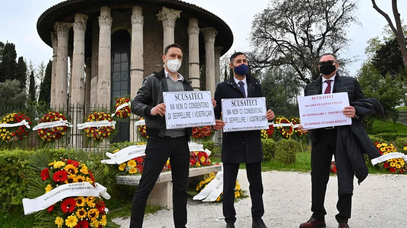 Fotografija: »Oprostite, ne dovolijo nam, da bi pokopali vaše drage,« je pisalo na transparentih protestnikov. Postopek za pridobitev dovoljenja za upepelitev v Rimu v povprečju traja od 35 do 40 dni. FOTO: Andreas Solaro/AFP