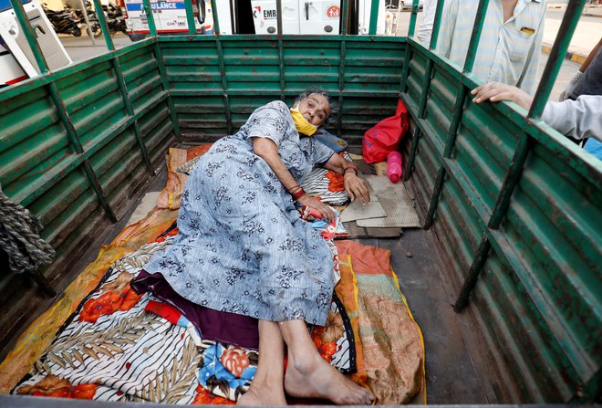 Bolnike vozijo v bolnišnice s tovornjaki. FOTO: Amit Dave/Reuters