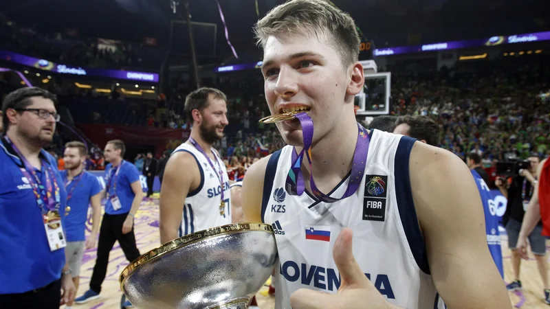 Fotografija: Tako se je za takrat 18-letnega Luko Dončića končalo EP 2017: s šampionskim pokalom v rokah, z zlato kolajno med zobmi in z uvrstitvijo v peterko prvenstva skupaj z Goranom Dragićem. FOTO: Blaž Samec/Delo