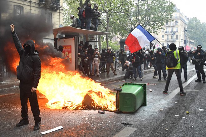 V Parizu je policija protestnike, ki so razbijali izložbe trgovin in poslovalnic bank ter zažigali smetnjake, razgnala s solzivcem. FOTO: Bertrand Guay/AFP