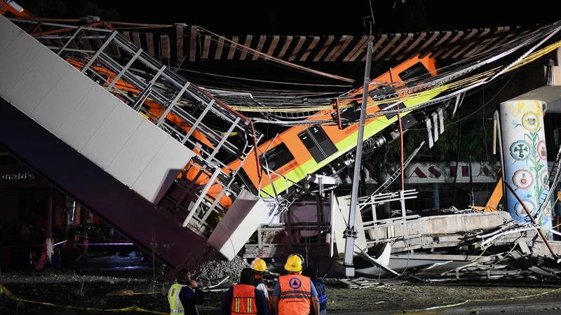 Fotografija: Televizije so predvajale posnetke varnostnih kamer, ki so ujele, kako so vagoni padli nekaj metrov globoko na cesto, kjer so bili avtomobili. FOTO: Pedro Pardo/AFP