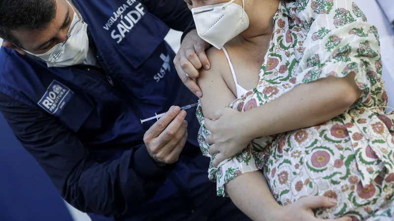 Fotografija: Cepiva proti covidu niso bila posebej testirana na nosečnicah, kar je tudi glavni argument proti uvrščanju nosečnic na prednostne liste. Prizor cepljenja je iz Ria de Janeira. FOTO: Ricardo Moraes/Reuters