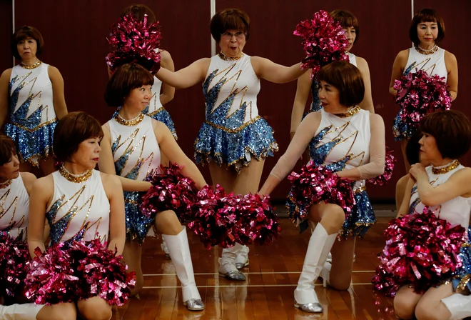 89-letna Fumie Takino, ustanoviteljica navijaške skupine starejših občank Japan Pom Pom, in druge članice se fotografirajo, pred začetkom vaje za spletni nastop v Tokiu. FOTO: Kim Kyung-hoon/Reuters<br />
<br />
<br />
