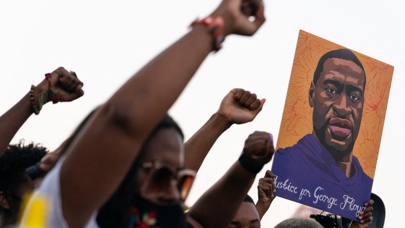 Fotografija: Ljudje so tudi po obsodbi Dereka Chauvina dvigali pesti in portret Georga Floyda. Njegova smrt je povzročila silovite proteste proti policijskemu nasilju v ZDA, kasneje pa so se protesti razširili tudi na simbole rasizma v ZDA. FOTO: Elijah Nouvelage/AFP