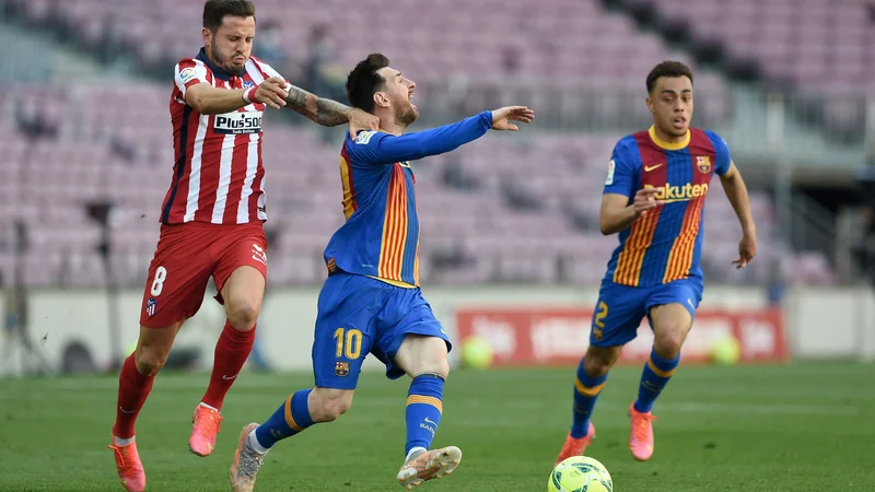 Fotografija: Takole je Oblakov soigralec Saul Niguez poskusil ustaviti Barceloninega zvezdnika Lionela Messija. FOTO: Josep Lago/AFP