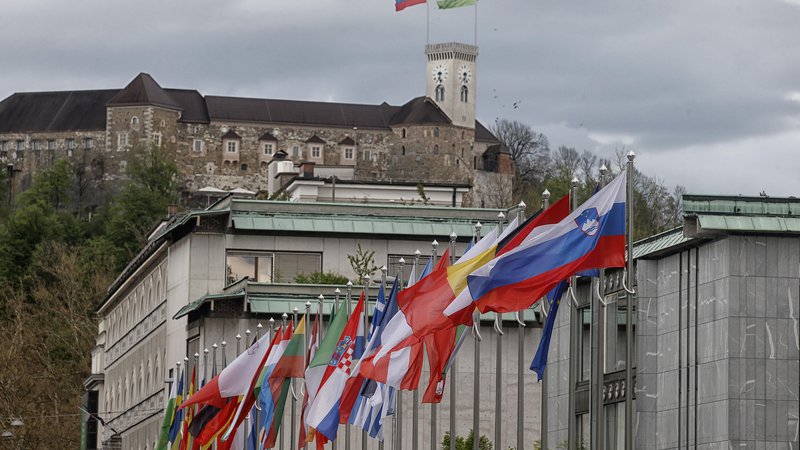 Fotografija: Zastave v čast slovenskemu predsedovanju že plapolajo, ime glavnega govorca pa še ni znano. FOTO: Blaž Samec