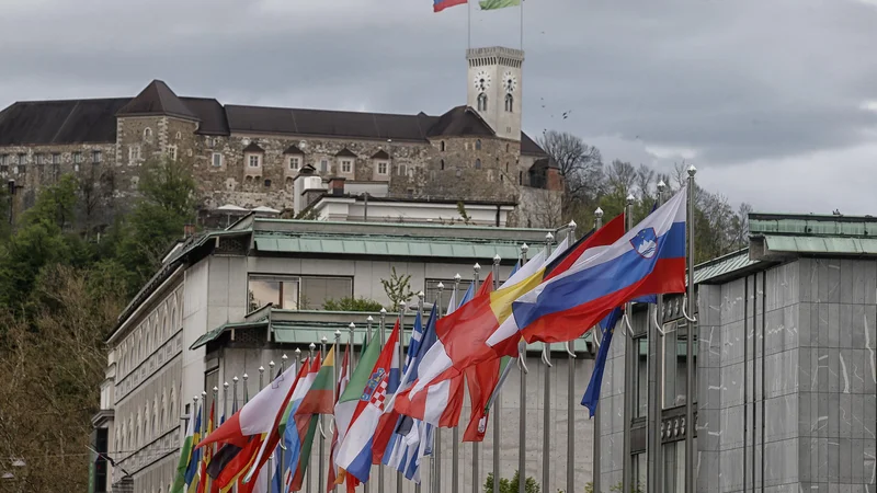 Fotografija: Zastave v čast slovenskemu predsedovanju že plapolajo, ime glavnega govorca pa še ni znano. FOTO: Blaž Samec