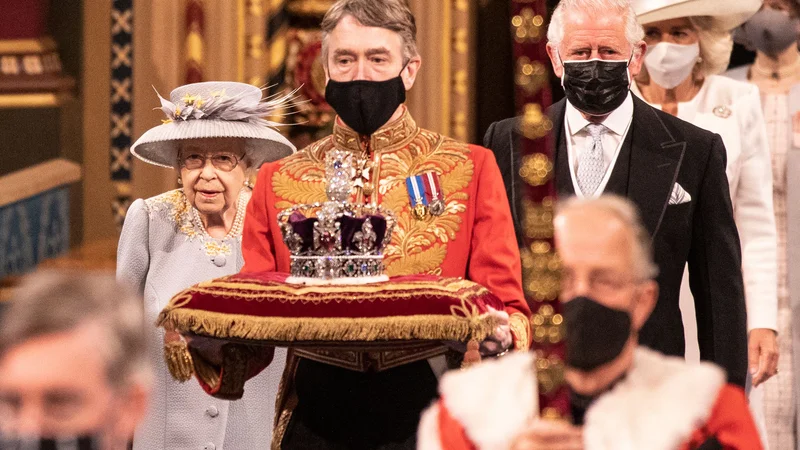 Fotografija: Britanska kraljica Elizabeta II. je s predstavitvijo programa vlade odprla novo zasedanje britanskega parlamenta. Pri tem je kot prednostno nalogo poudarila okrevanje po pandemiji. To je bil za kraljico prvi večji javni dogodek po smrti njenega moža princa Filipa. FOTO: Richard Pohle/Afp