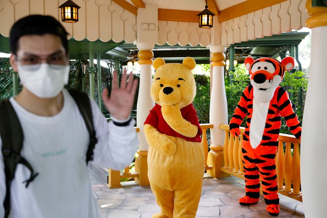 FILE PHOTO: A visitor greets Disney characters Winnie the Pooh and Tigger during the reopening day of Disneyland to the public, after a second closure due to the coronavirus disease (COVID-19) outbreak, in Hong Kong, China, September 25, 2020. REUTERS/Tyrone Siu/File Photo Foto Tyrone Siu Reuters