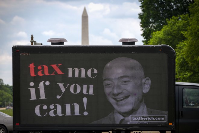 Zagovorniki višjih davkov za milijonarje in milijarderje proti najbogatejšemu zemljanu Jeffu Bezosu. FOTO: Drew Angerer/AFP