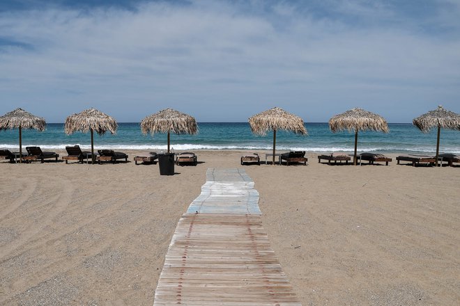Plaže na grških otokih so še prazne, vendar je že samo turistična agencija TUI do konca maja napovedala 120 poletov v to državo. FOTO: Louisa Gouliamaki/AFP