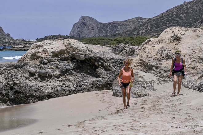 Britanski turistki na za zdaj še samotnih grških plažah. FOTO: Louisa Gouliamaki/AFP
