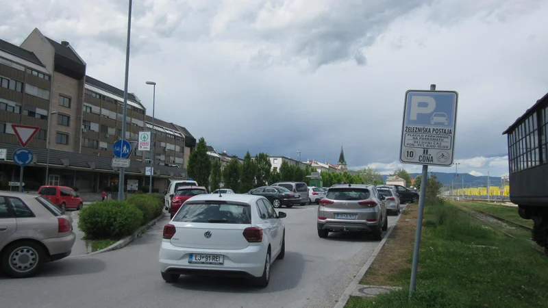 Fotografija: Prvi del parkirišča pri železniški postaji je nabito poln, odkar je 40 parkirnih mest na tem parkirišču ločenih z zapornico. FOTO: Špela Kuralt/Delo