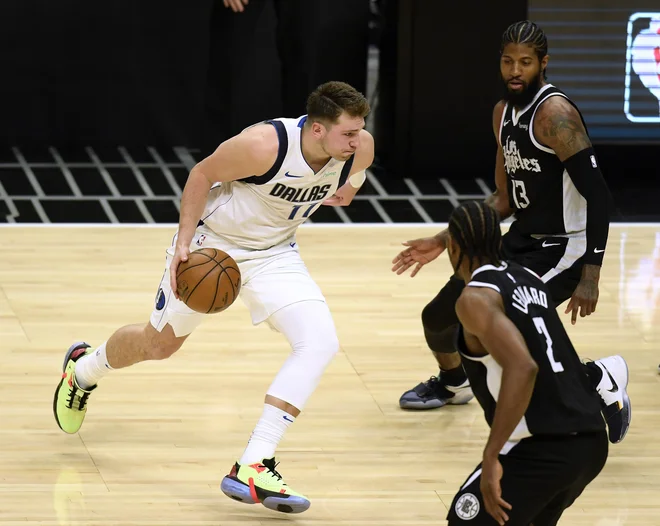 Luka Dončić je dobro vedel, kaj mora narediti, ko sta ga pokrivala tako Paul George (13) kot Kawhi Leonard (2). FOTO Harry How/AFP