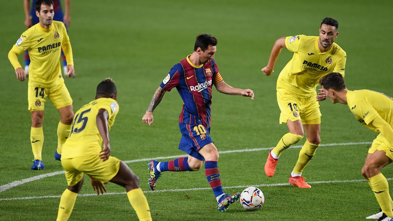 Fotografija: Lionel Messi obkrožen z igralci Villarreala, imenovanega tudi rumena podmornica, saj igralci nosijo rumene drese. FOTO:Josep Lago/AFP
