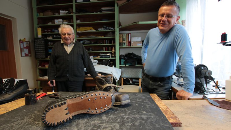 Fotografija: Oče in sin Kisilakova z okovanim ročno izdelanim čevljem, kakršne so čevljarji izdelovali nekoč. Fotografije Jože Pojbič