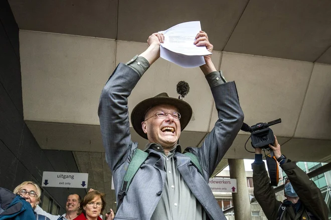 Direktor nizozemske okoljevarstvene organizacije Milieudefensie Donald Pols je zmagoslavno odkorakal s haaškega sodišča. FOTO: Remko De Waal/AFP