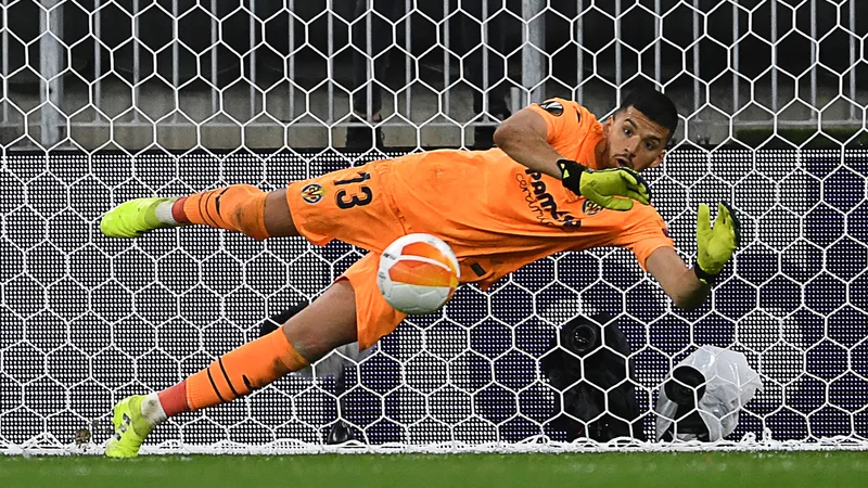 Fotografija: Geronimo Rulli je takole ubranil strel Davidu de Gei, vratarju Manchester Uniteda, za najodmevnejšo lovoriko Villarreala. FOTO: Adam Warzawa/AFP