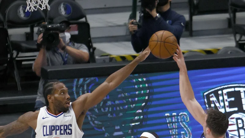 Kawhi Leonard ustavlja Luka Dončića na šesti tekmi prvega kroga končnice v Dallasu. FOTO: Tom Pennington/AFP