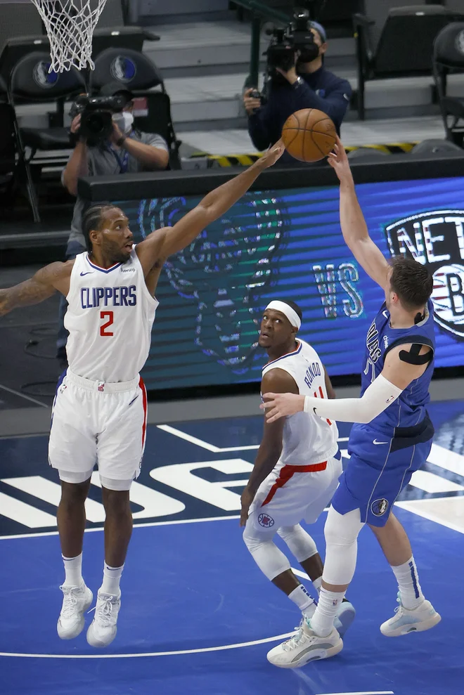 Kawhi Leonard ustavlja Luka Dončića na šesti tekmi prvega kroga končnice v Dallasu. FOTO: Tom Pennington/AFP
