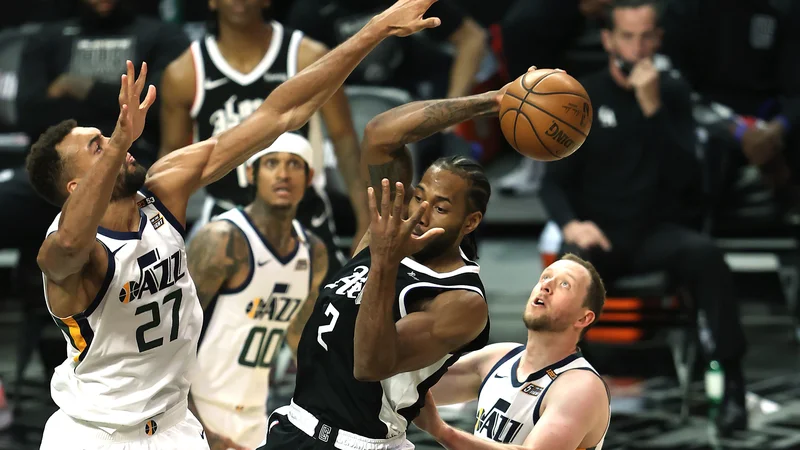 Fotografija: Ko je Kawhi Leonard (v sredini) razigran, mu niti najboljši obrambni košarkar v NBA Rudy Gobert (levo) ni kos. FOTO: Sean M. Haffey/AFP