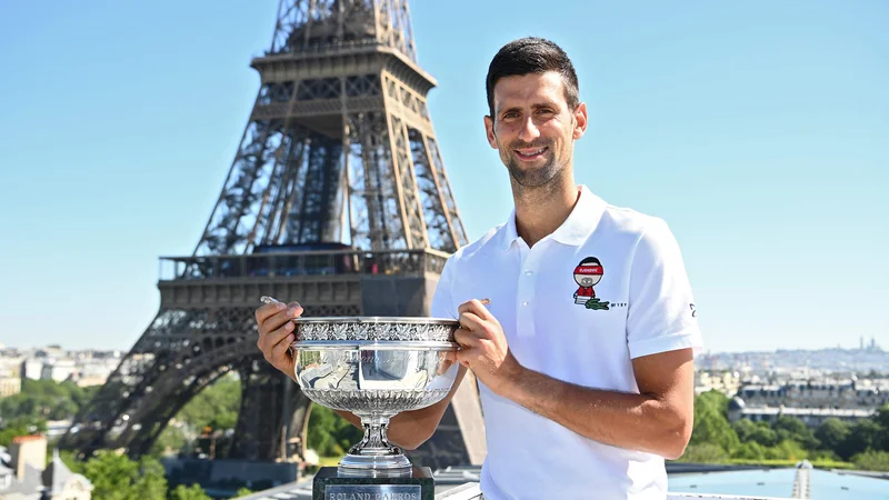Fotografija: Novak Đoković je ponosno pred znamenitim pariškim stolpom pokazal svojo 19. lovoriko s turnirjev za grand slam.
FOTO: Christophe Archambault/AFP
