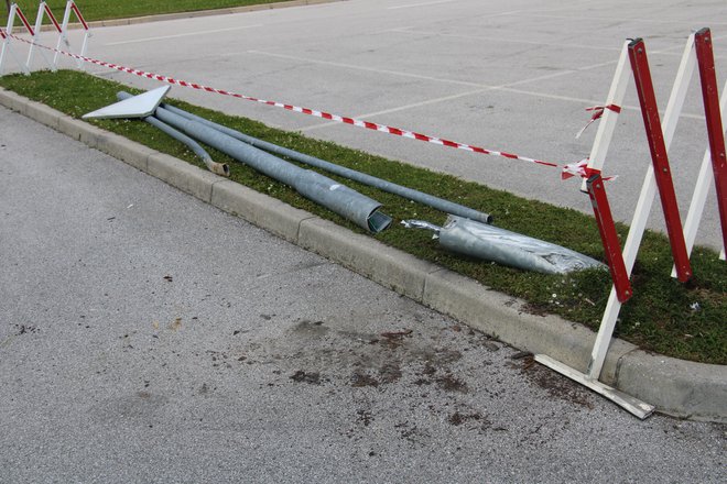 Poškodovan steber javne razsvetljave in prometni znak. FOTO: PU Celje