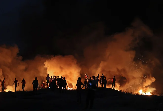 Palestinci so včeraj na meji Gaze in Izraela z zažiganjem pnevmatik demonstrirali proti izraelskemu proslavljanju obletnice zasedbe Vzhodnega Jeruzalema leta 1967. FOTO: Mahmud Hams/AFP