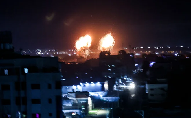 Eksplozije ponoči nad zgradbami v mestu Gaza. FOTO: Mahmud Hams/AFP
