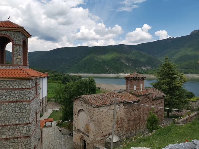 Pološki samostan ob jezeru iz 14. stoletja – nekoč visoko nad vasjo, zdaj tik ob gladini jezera. V njem so vedno živeli menihi, po novem pa tu biva redovnica. FOTO: Milena Zupanič