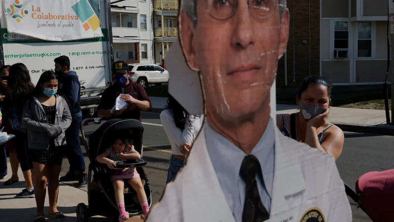 Fotografija: Podoba največjega ameriškega strokovnjaka za nalezljive bolezni dr. Anthonyja Faucija krasi vhod v kliniko za cepljenje proti covidu-19 v kraju Chelsea v zvezni državi Massachusetts. Foto Brian Snyder/Reuters