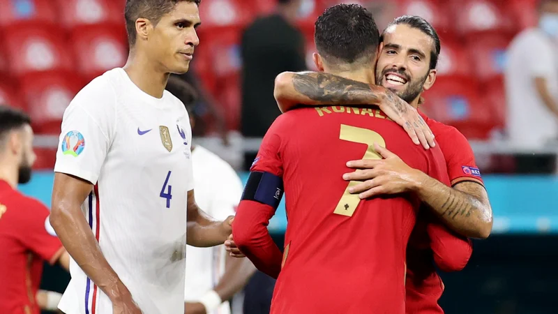 Rezervist Sergio Oliveira v objemu z Ronaldom po zadnjem sodnikovem žvižgu v Budimpešti. FOTO: Bernadett Szabo/Reuters