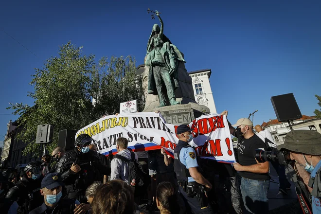 Skupinica provokatorjev na spomeniku. FOTO: Jože Suhadolnik/Delo