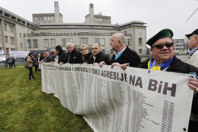 Preživeli Bošnjaki so se leta 2016 zbrali pred haaškim poslopjem in zahtevali pravico. FOTO: Michael Kooren/Reuters 