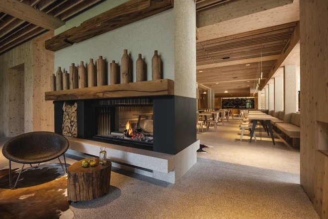 Velik kamin pregrajuje hotelski lobi od jedilnice. Vsa unikatna oprema je nastala v sodelovanju s slovenskimi izvajalci in proizvajalci. Foto Žiga Intihar